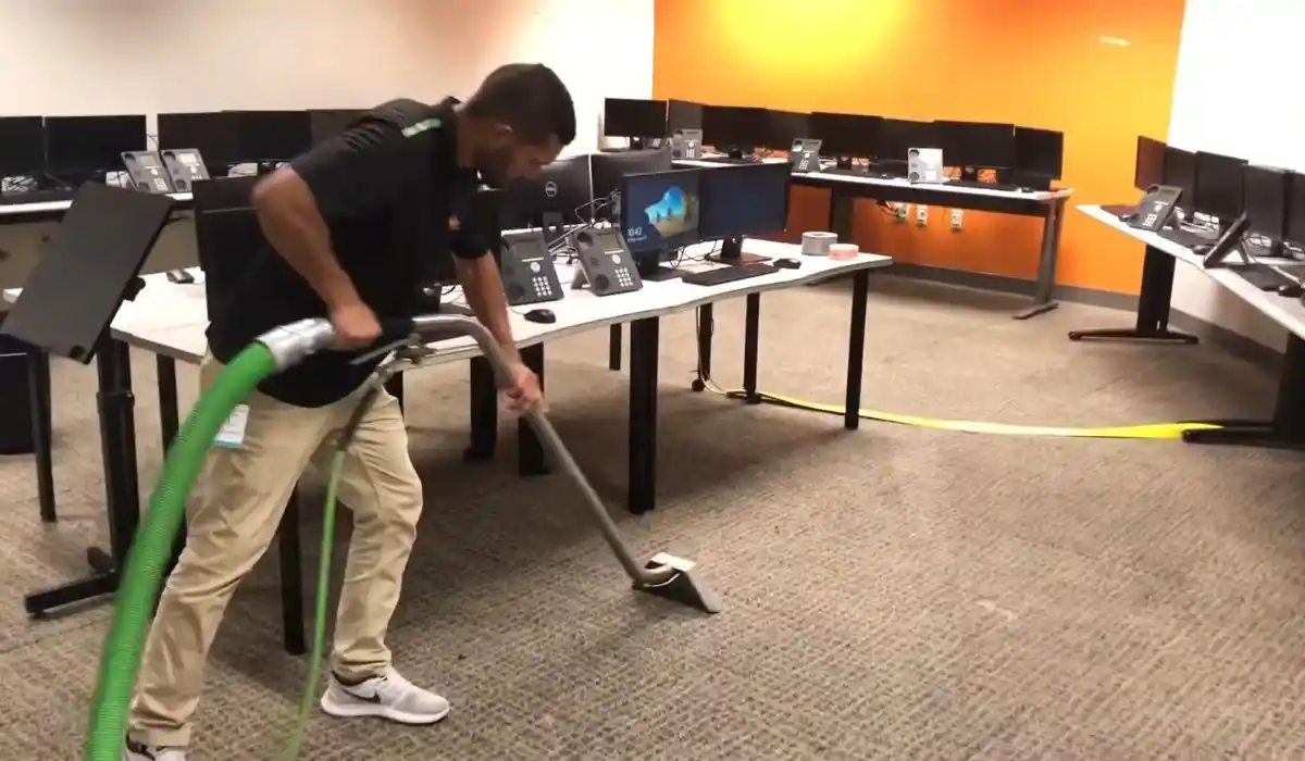 Technician performing commercial water extraction with a carpet wand during water damage restoration in Islip, NY